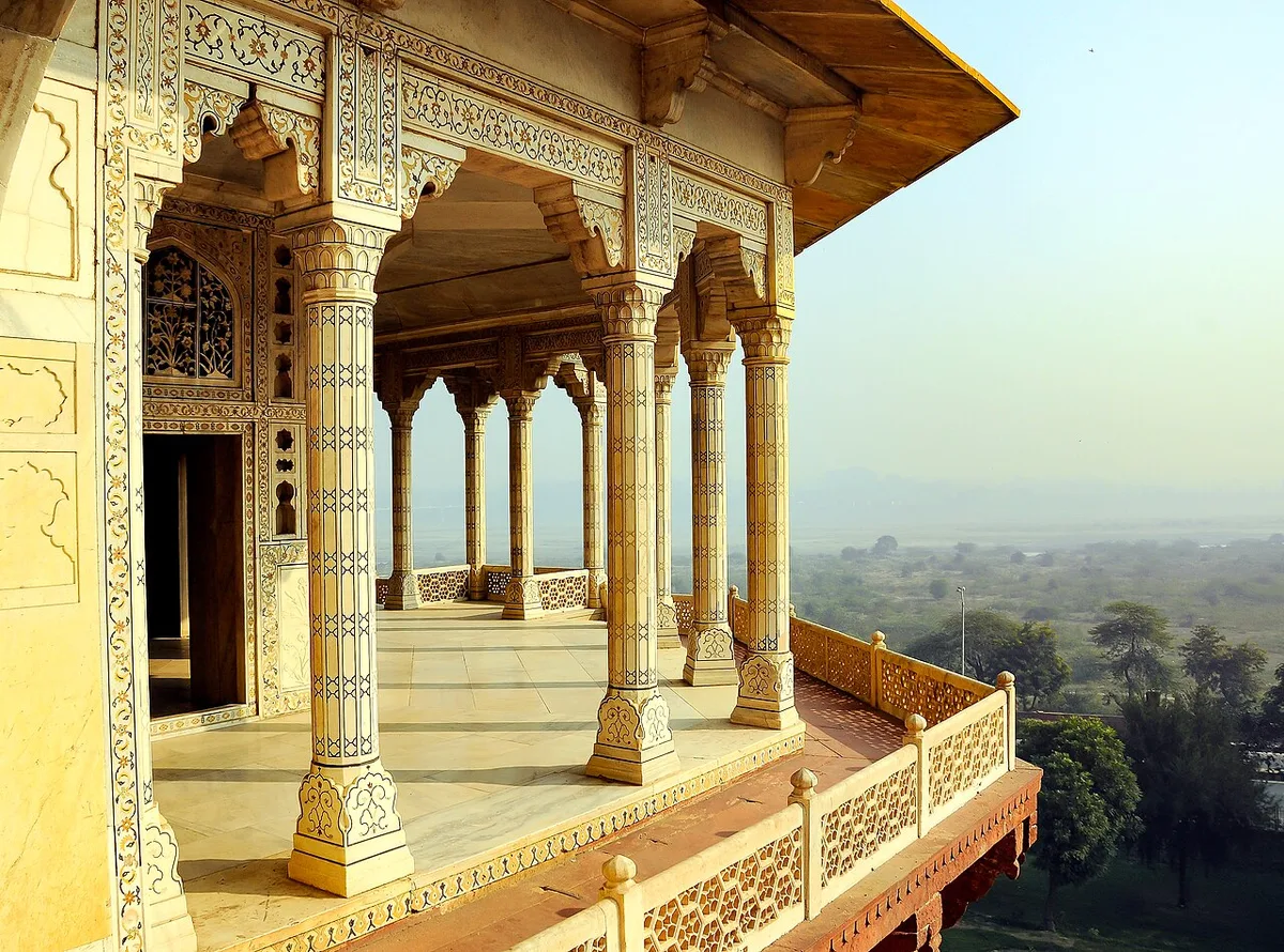 An inlaid marble pavilion balcony inside Agra Fort, its carved pillars overlooking the Yamuna plain