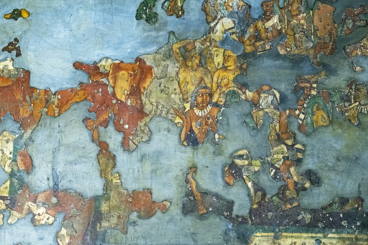 A fragment of ancient mural painting surviving on a wall of Cave 1 at Ajanta, its painted figures partly lost where the plaster has fallen away