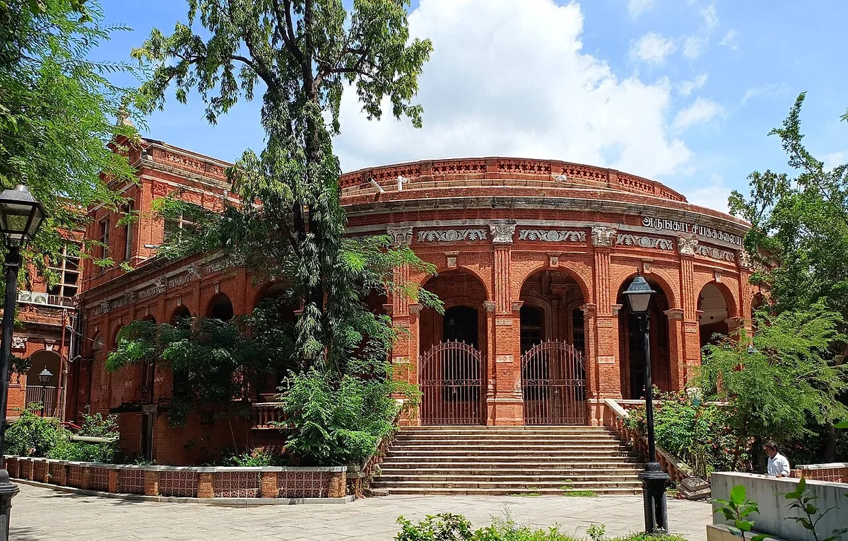 The red-brick circular building of the Government Museum complex on Pantheon Road, Egmore, Chennai, fronted by arches and trees