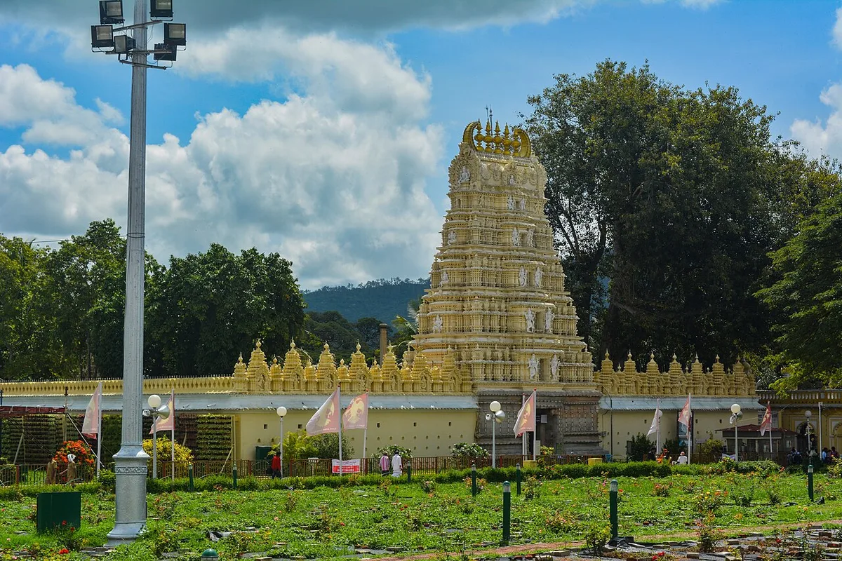 The golden gopuram of the Chamundeshwari Temple on Chamundi Hills, Mysuru, above its walled courtyard and gardens