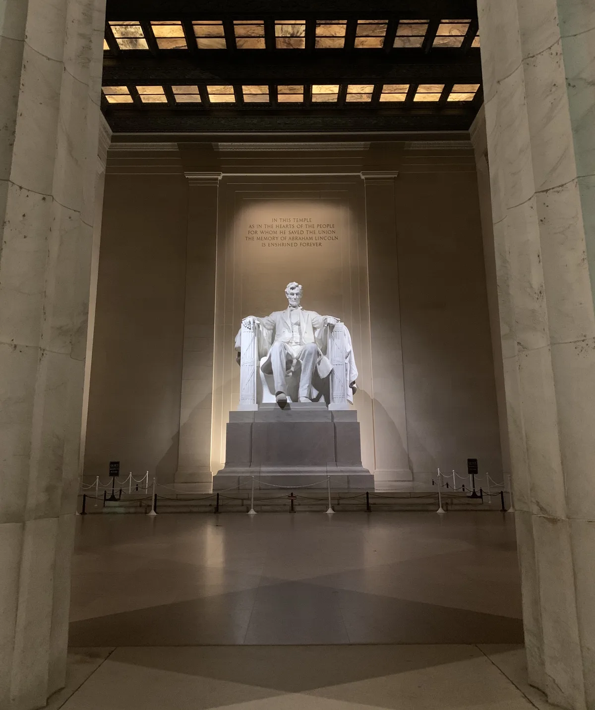 The seated statue of Abraham Lincoln inside the Lincoln Memorial at night