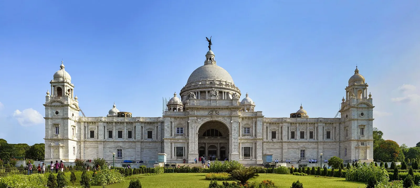 The Victoria Memorial in Kolkata seen across its gardens under a blue sky