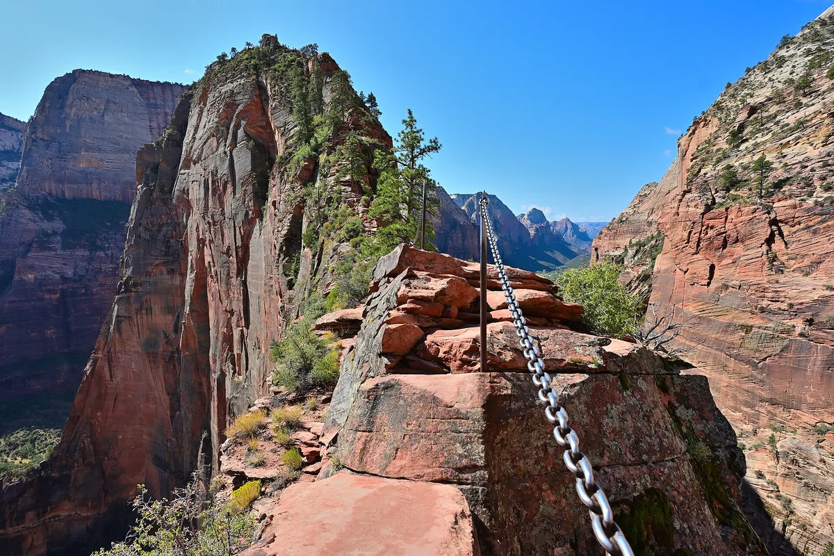 Hikers holding the chains on the narrow Angels Landing ridge, high above the floor of Zion Canyon